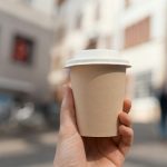 Hand holding paper coffee cup. Coffee to go